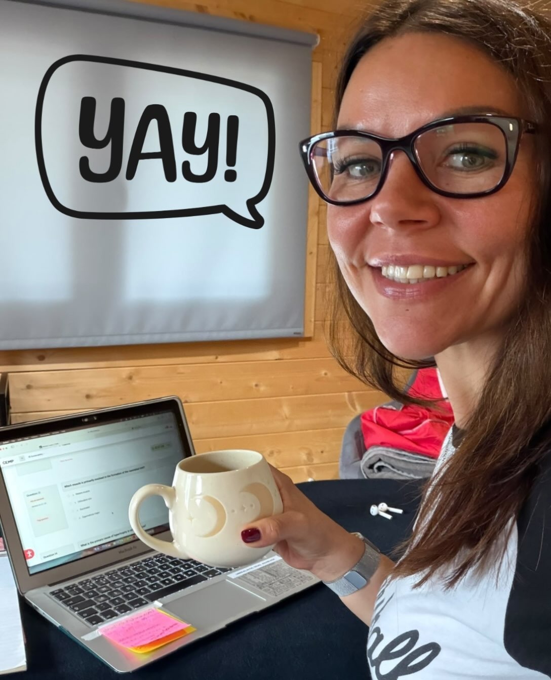 Laura at her laptop with a coffee, studying